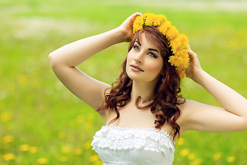 Image showing beautiful girl with dandelion flowers in green field