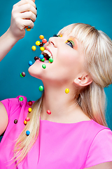 Image showing beautiful blond girl with many colorful candies