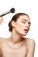 Image showing girl applying powder on face isolated on white