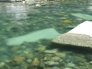 Image showing grey polished rocks and green river water