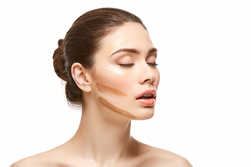 Image showing girl applying foundation on face isolated on white