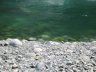 Image showing grey polished rocks and green river water