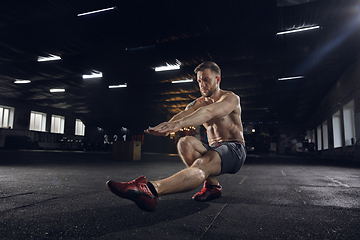 Image showing Young healthy male athlete doing exercises in the gym