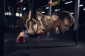 Image showing Young healthy male athlete doing exercises in the gym