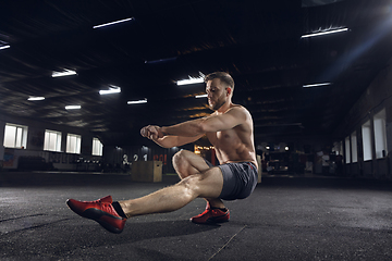 Image showing Young healthy male athlete doing exercises in the gym