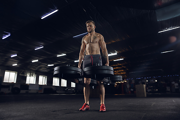 Image showing Young healthy male athlete doing exercises in the gym