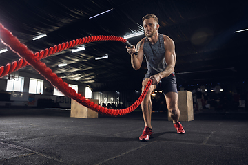 Image showing Young healthy male athlete doing exercises in the gym