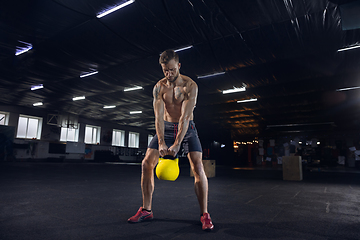 Image showing Young healthy male athlete doing exercises in the gym