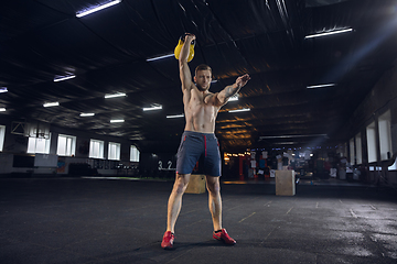 Image showing Young healthy male athlete doing exercises in the gym