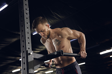 Image showing Young healthy male athlete doing exercises in the gym