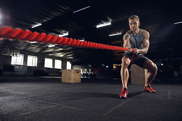 Image showing Young healthy male athlete doing exercises in the gym