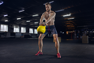 Image showing Young healthy male athlete doing exercises in the gym