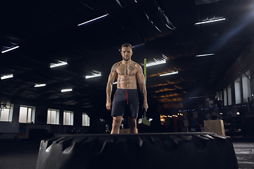 Image showing Young healthy male athlete doing exercises in the gym