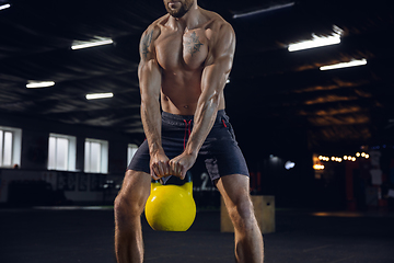 Image showing Young healthy male athlete doing exercises in the gym