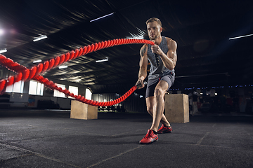 Image showing Young healthy male athlete doing exercises in the gym