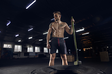 Image showing Young healthy male athlete doing exercises in the gym