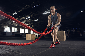 Image showing Young healthy male athlete doing exercises in the gym