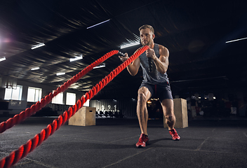 Image showing Young healthy male athlete doing exercises in the gym