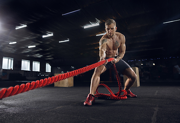 Image showing Young healthy male athlete doing exercises in the gym