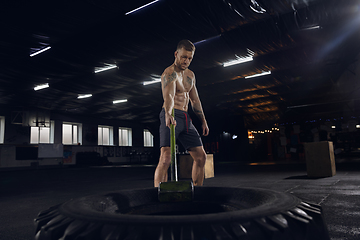 Image showing Young healthy male athlete doing exercises in the gym