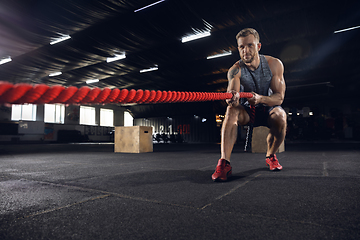 Image showing Young healthy male athlete doing exercises in the gym