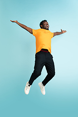 Image showing Full length portrait of African young man isolated over blue studio background with copyspace