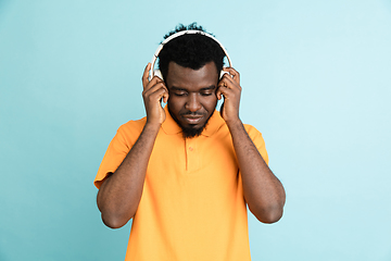 Image showing African man\'s portrait isolated over blue studio background with copyspace