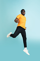 Image showing Full length portrait of African young man isolated over blue studio background with copyspace