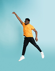 Image showing Full length portrait of African young man isolated over blue studio background with copyspace