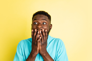 Image showing Portrait of young African man isolated over yellow studio background with copyspace.