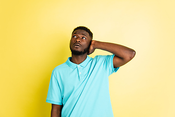 Image showing Portrait of young African man isolated over yellow studio background with copyspace.