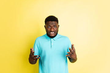 Image showing Portrait of young African man isolated over yellow studio background with copyspace.