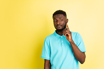 Image showing Portrait of young African man isolated over yellow studio background with copyspace.