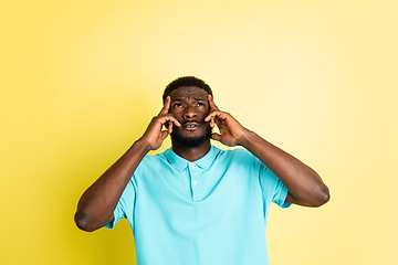 Image showing Portrait of young African man isolated over yellow studio background with copyspace.