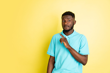 Image showing Portrait of young African man isolated over yellow studio background with copyspace.