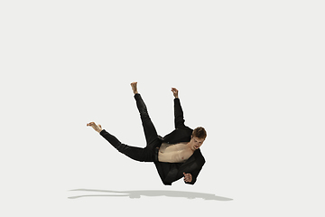 Image showing Man in casual style clothes jumping and dancing isolated on white background. Art, motion, action, flexibility, inspiration concept. Flexible caucasian ballet dancer.