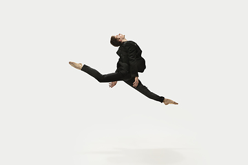 Image showing Man in casual style clothes jumping and dancing isolated on white background. Art, motion, action, flexibility, inspiration concept. Flexible caucasian ballet dancer.