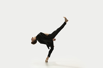 Image showing Man in casual style clothes jumping and dancing isolated on white background. Art, motion, action, flexibility, inspiration concept. Flexible caucasian ballet dancer.