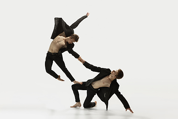 Image showing Man in casual style clothes jumping and dancing isolated on white background. Art, motion, action, flexibility, inspiration concept. Flexible caucasian ballet dancer.