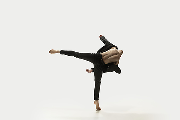 Image showing Man in casual style clothes jumping and dancing isolated on white background. Art, motion, action, flexibility, inspiration concept. Flexible caucasian ballet dancer.