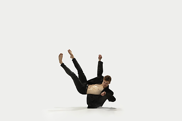 Image showing Man in casual style clothes jumping and dancing isolated on white background. Art, motion, action, flexibility, inspiration concept. Flexible caucasian ballet dancer.