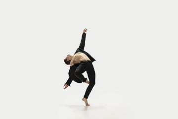 Image showing Man in casual style clothes jumping and dancing isolated on white background. Art, motion, action, flexibility, inspiration concept. Flexible caucasian ballet dancer.