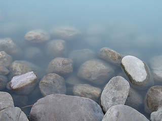 Image showing grey polished rocks and green river water