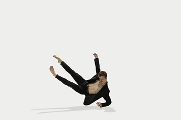 Image showing Man in casual style clothes jumping and dancing isolated on white background. Art, motion, action, flexibility, inspiration concept. Flexible caucasian ballet dancer.