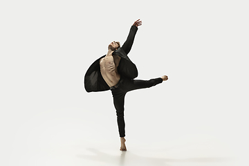 Image showing Man in casual style clothes jumping and dancing isolated on white background. Art, motion, action, flexibility, inspiration concept. Flexible caucasian ballet dancer.