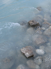 Image showing grey polished rocks and green river water