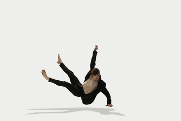 Image showing Man in casual style clothes jumping and dancing isolated on white background. Art, motion, action, flexibility, inspiration concept. Flexible caucasian ballet dancer.