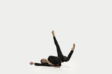 Image showing Man in casual style clothes jumping and dancing isolated on white background. Art, motion, action, flexibility, inspiration concept. Flexible caucasian ballet dancer.