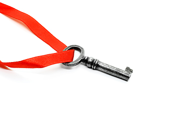 Image showing Vintage silver key with red ribbon on white background