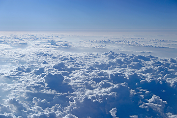 Image showing Flight over clouds. Wonderful panorama from window of plane with white clouds